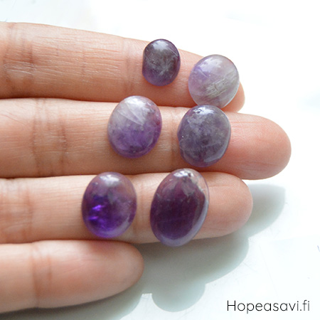 Ametisti *Kivi Special* pyrhiottu kapussi, soikea, kuvassa #AT10, mitat noin 10x8mm, paksuus noin 4.1mm, uniikki yksittiskappale, B-luokka, kiven vasemmassa reunassa suora kohta